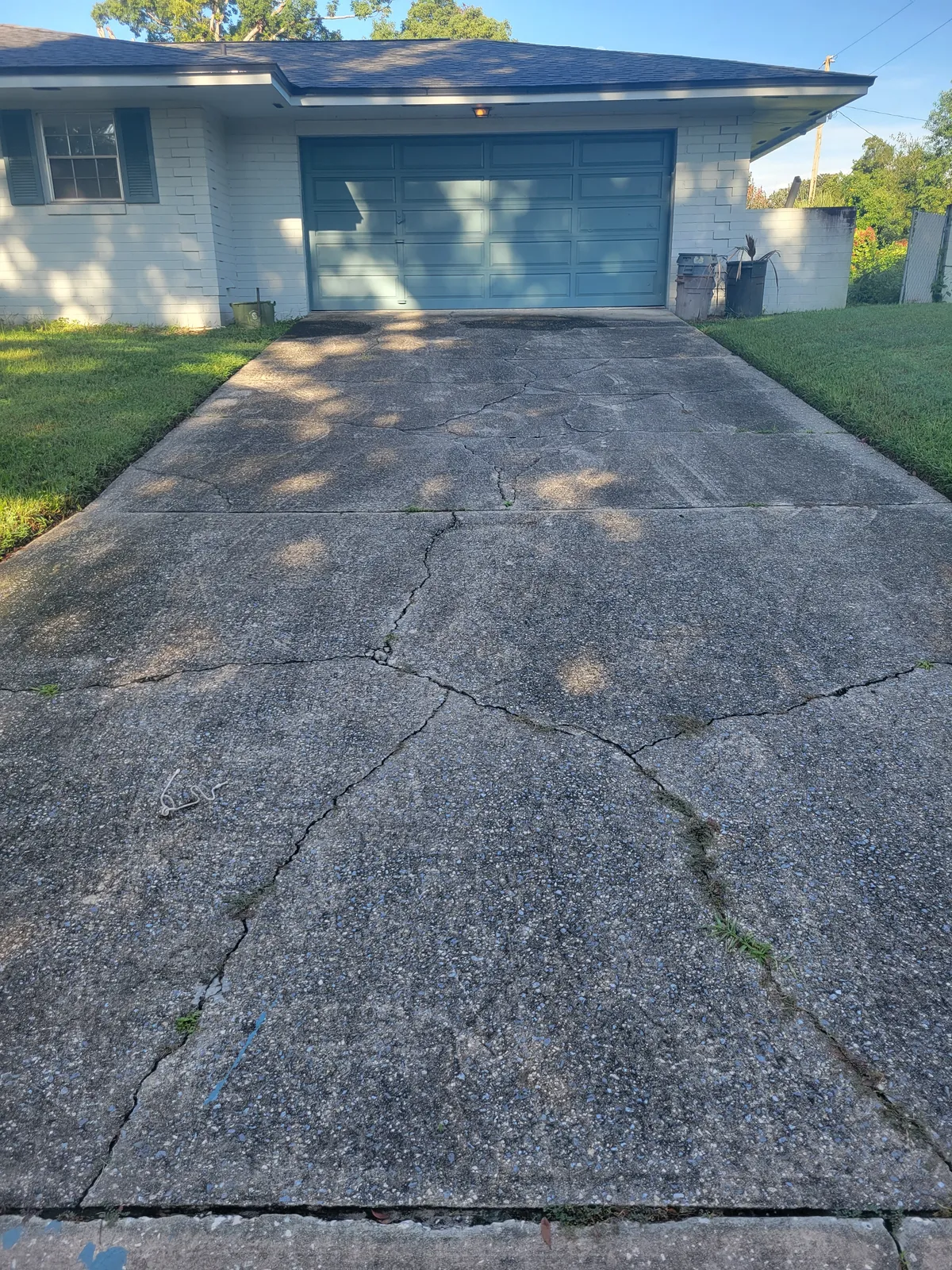 Before: Three years of ground-in dirt and tire marks stripped off a two-car driveway.